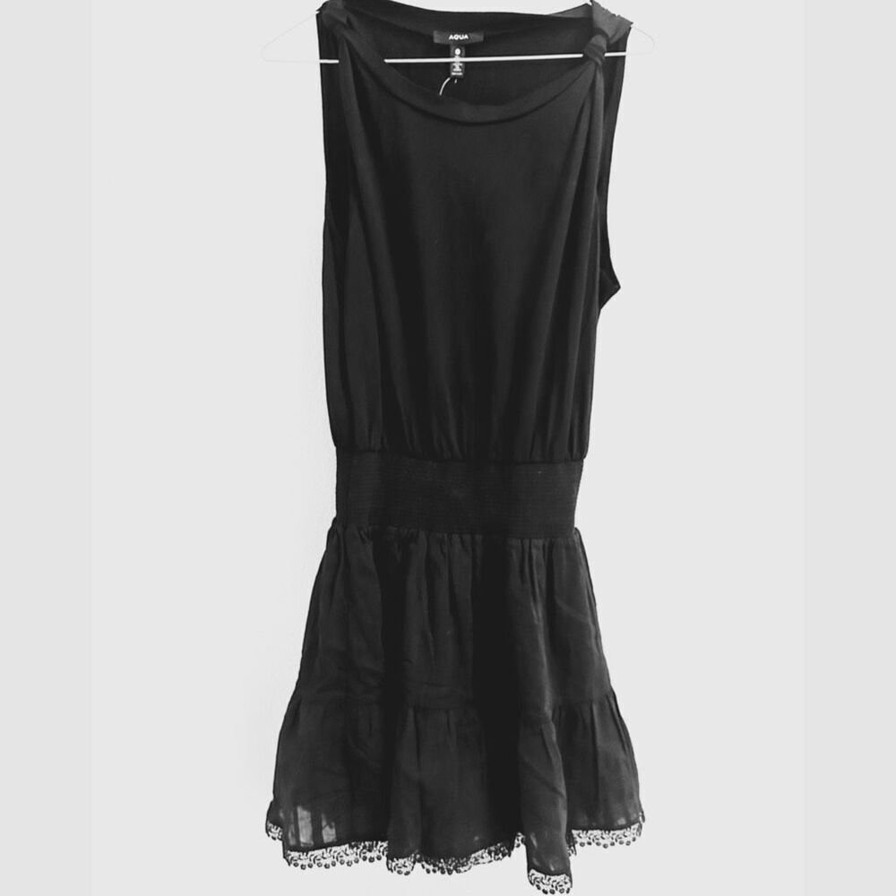 NWT AQUA black babydoll-style mini dress with eyelet lace details on the hem. Si
